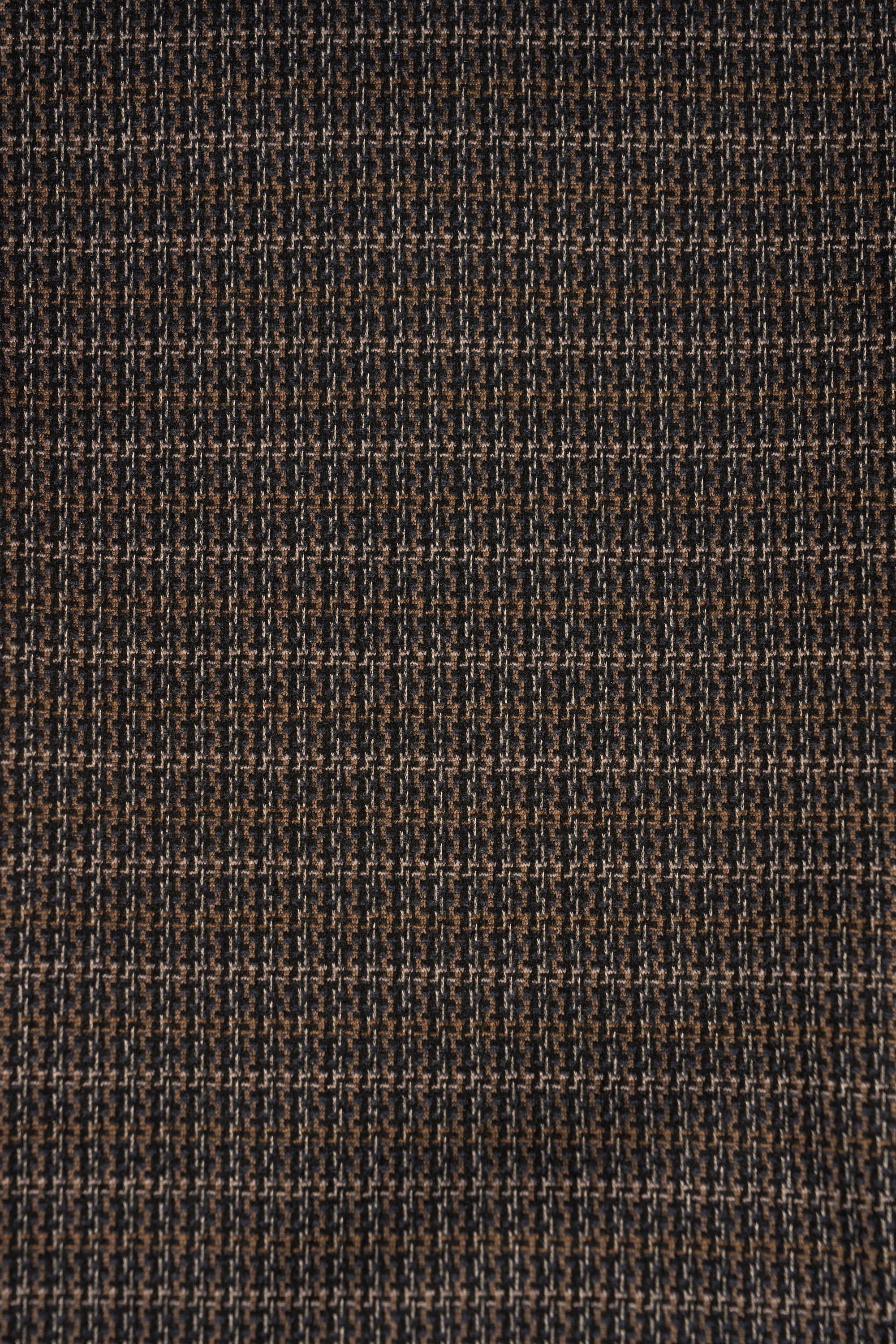Close-up of a small houndstooth fabric in brown, beige, and black—ideal for Vassalli's Bay Knit Pull On - Sutton—creating a textured, geometric look perfect for modern slim leg pant styles.