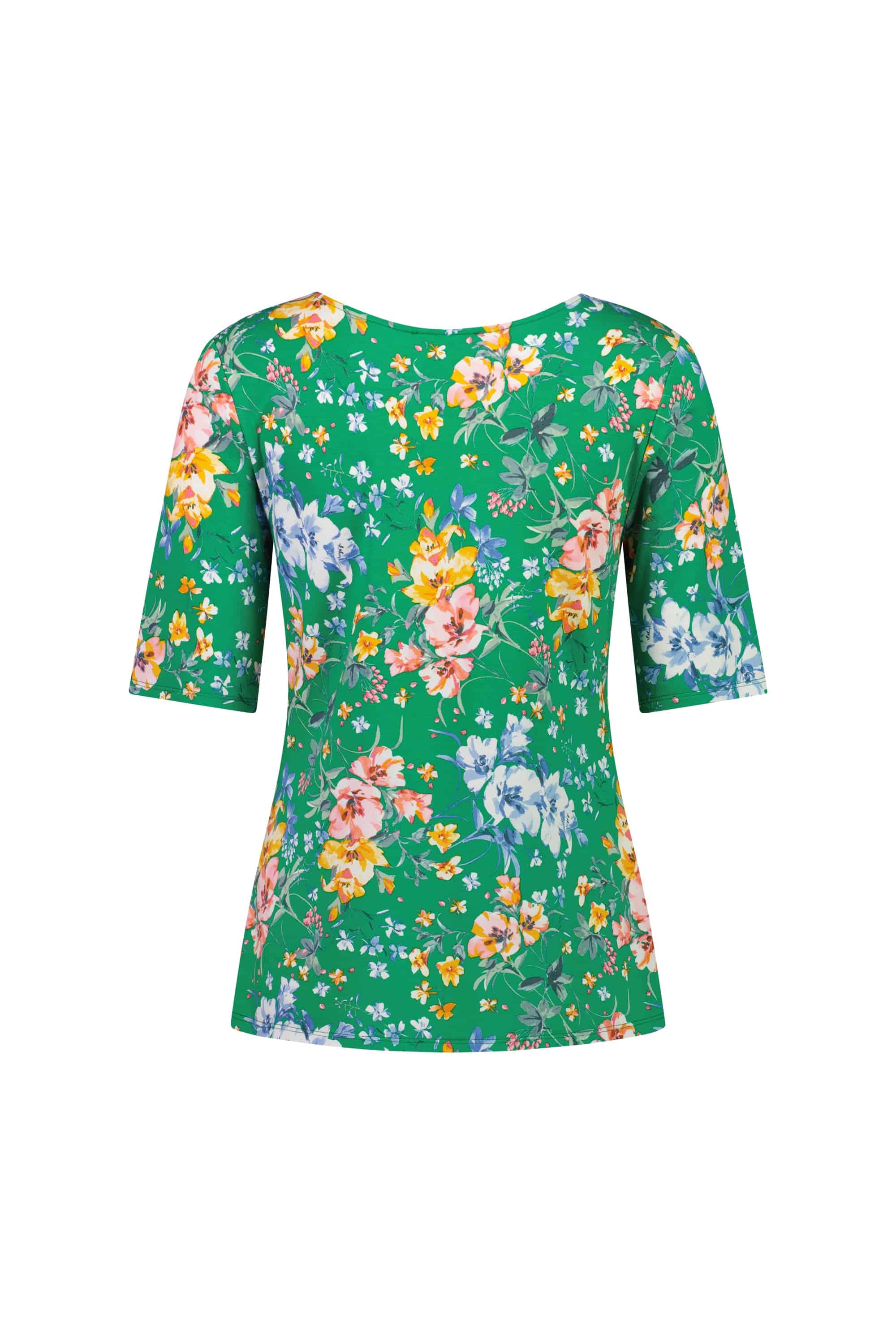 The Carmen Top - Lush by Vassalli is a green relaxed fit short-sleeve shirt with a colorful floral pattern in pink, yellow, blue, and white, shown from the back.