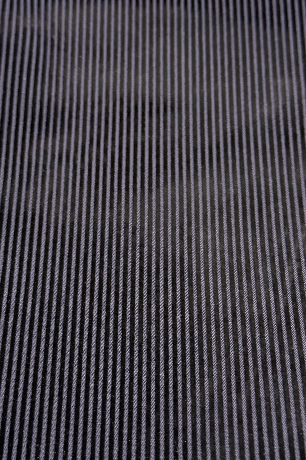 Close-up of navy and black striped fabric with vertical ridges, showing the corduroy texture pattern featured in Vassalli's Bay Pull On pants.