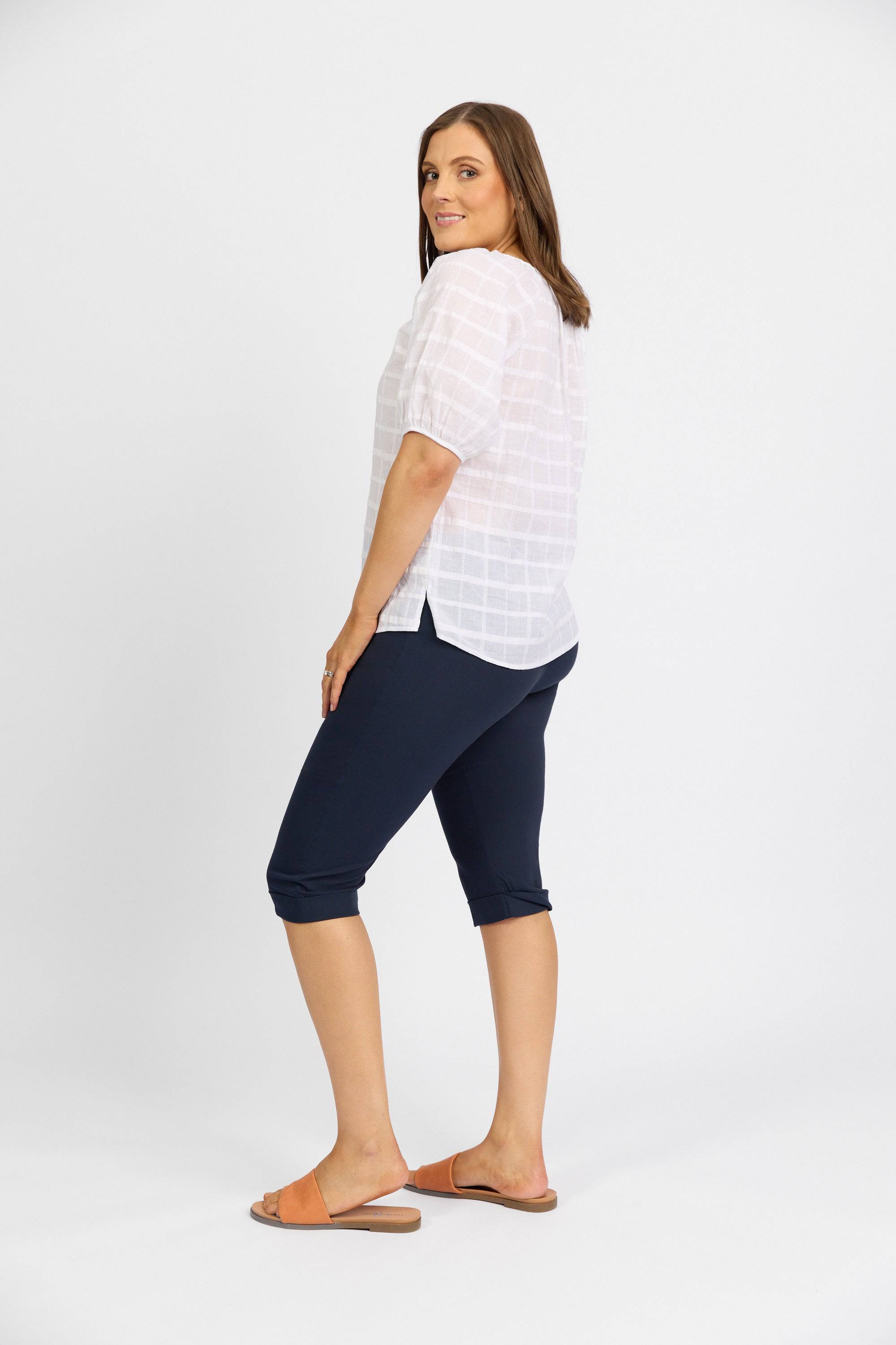 A woman stands sideways, looking over her shoulder, wearing Vassalli’s Paris Short - Inka against a plain white background.