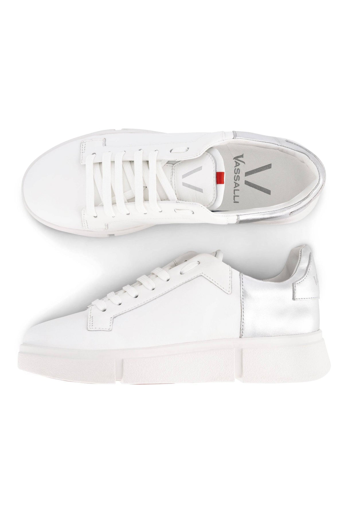 Two Vassalli VS-001 White/Silver laced sneakers with thick white soles and laces; one shown from the top, one from the side, both featuring a metallic silver heel accent for a modern twist on a classic look.