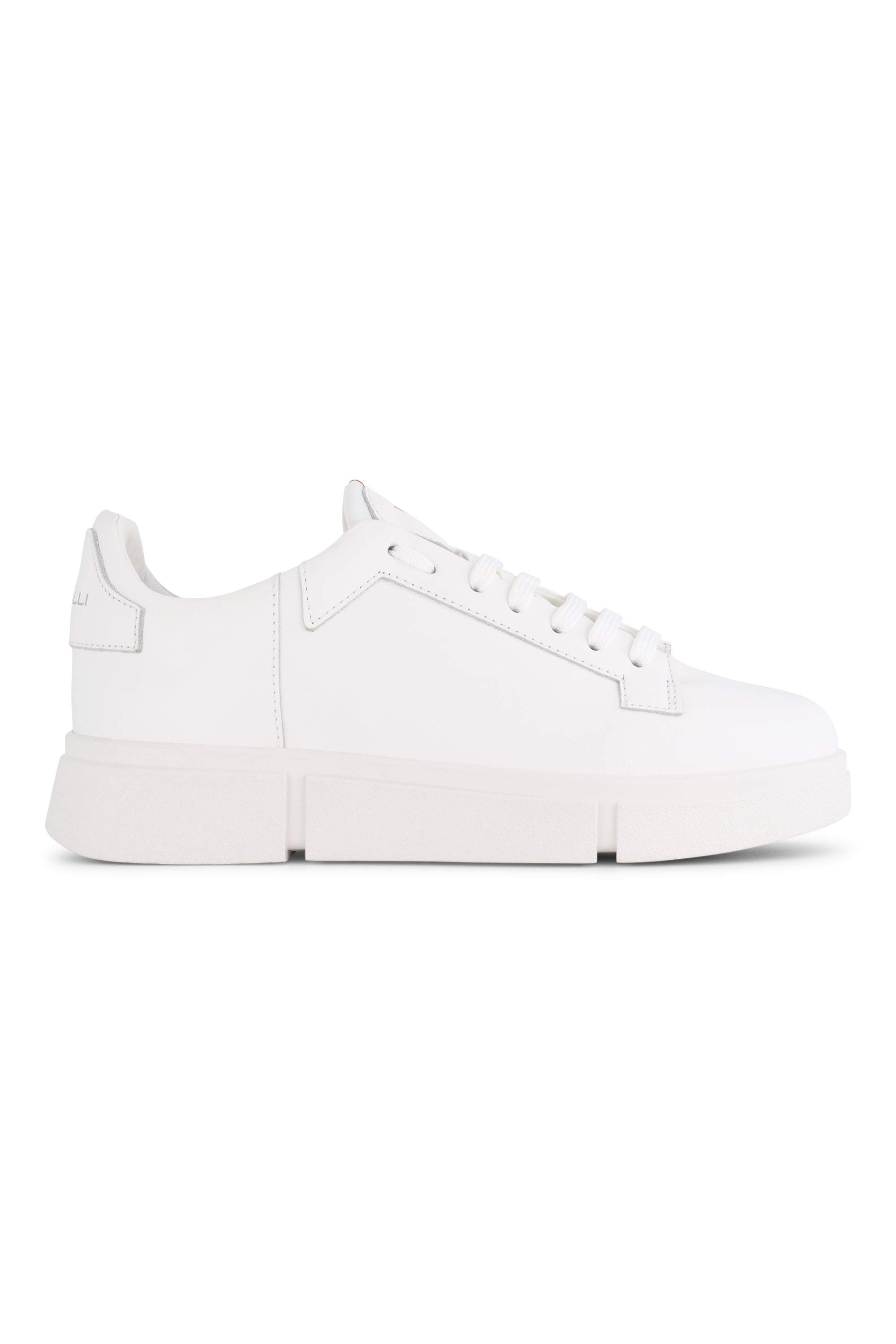The Vassalli VS-001 White/White Laced Sneaker features a plain white low-top leather design with minimal stitching, lace-up closure, and a thick rubber sole, shown from the side on a white background. Inspired by classic Vassalli platform sneakers.