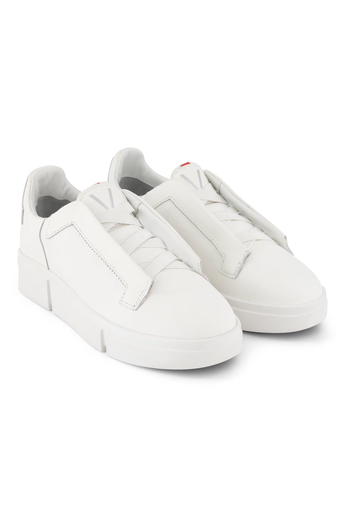 A pair of VS-003 White/White - Laceless Sneaker minimalist white leather platform sneakers with wide laces and a V logo on the tongue.
