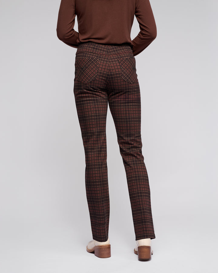 Model wears the Vassalli Bay Pull On - Cherry high-waisted plaid slim pants with an elasticated waistband and light heels, styled with a brown long-sleeve top, standing back to camera against a plain light background.