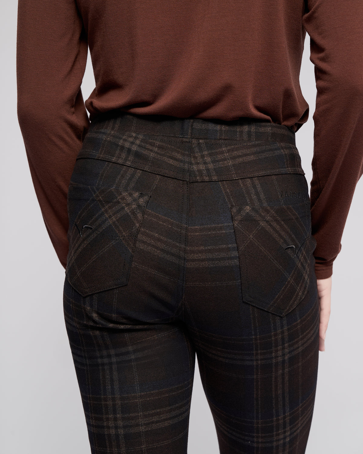 A person is shown from the back wearing Vassalli's Bay Pull On - Hugo: a dark plaid slim pant with an elasticated waistband and back pockets, highlighting its fitted design against a plain background.