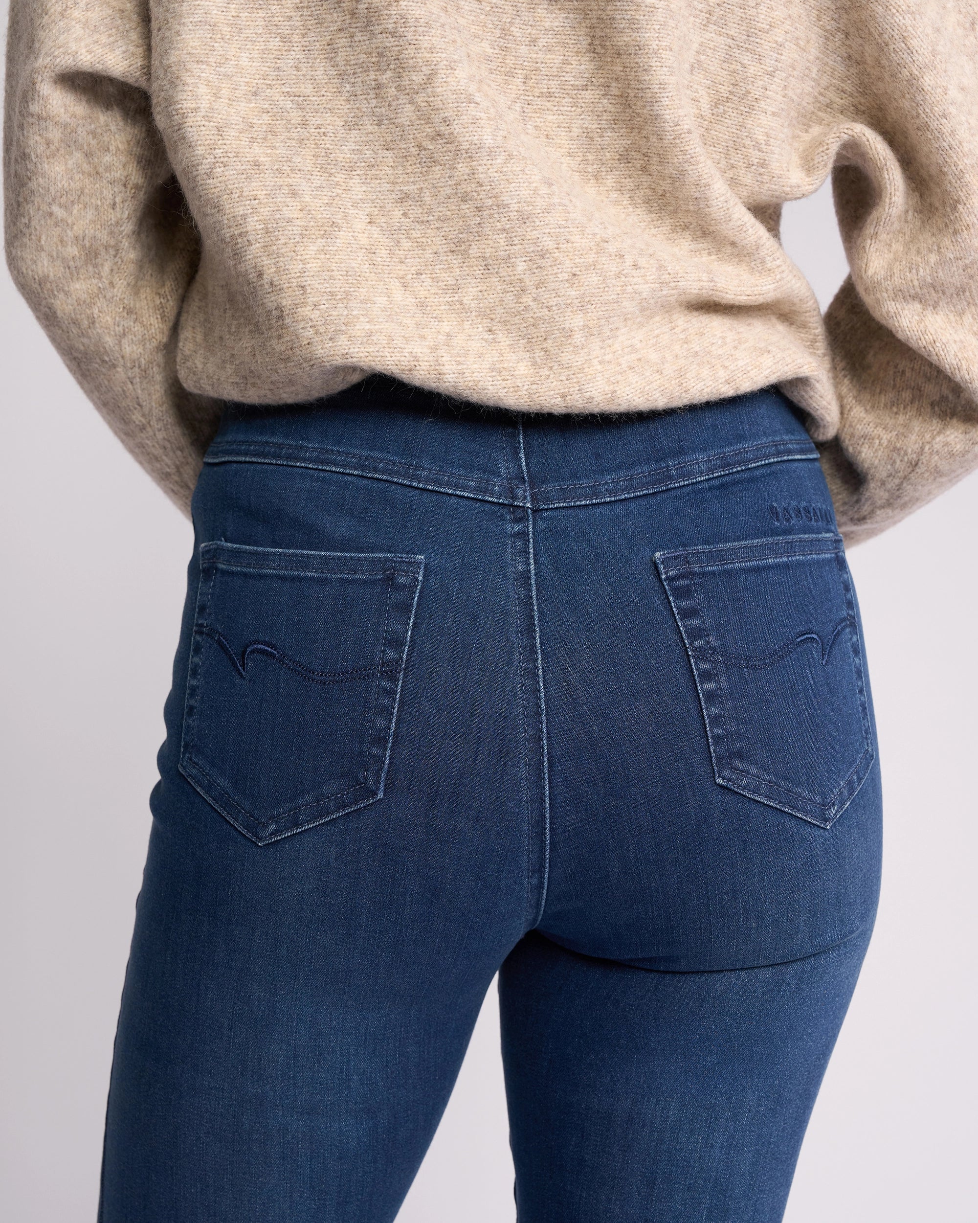 A person is seen from the back wearing Vassalli's Bay Pull On - Blue Denim (With Front Fade), highlighting the slim-leg jean’s pockets and waistband.