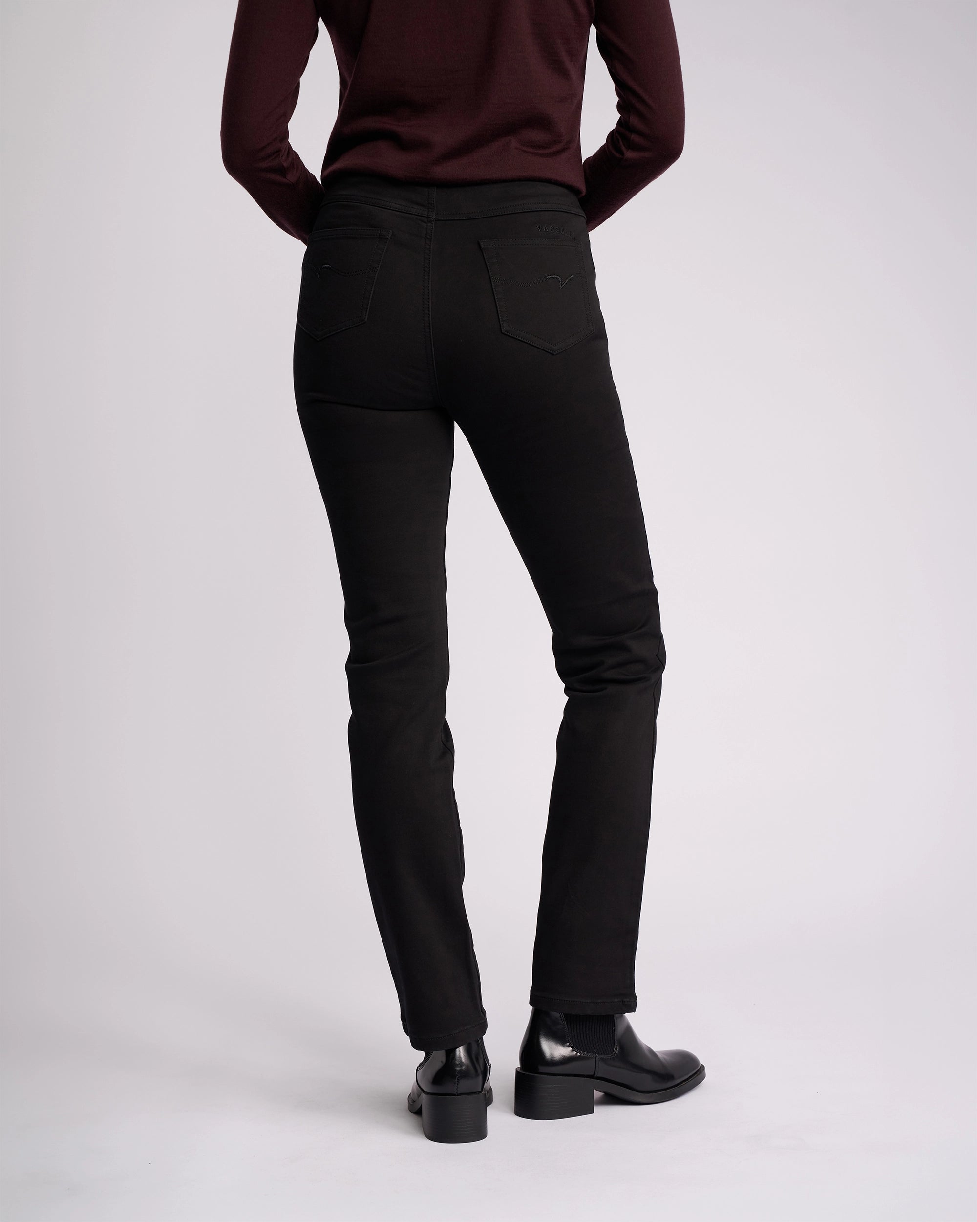 A person stands facing away from the camera against a plain light background, wearing Vassalli’s Bay Knit Pull On - Black.