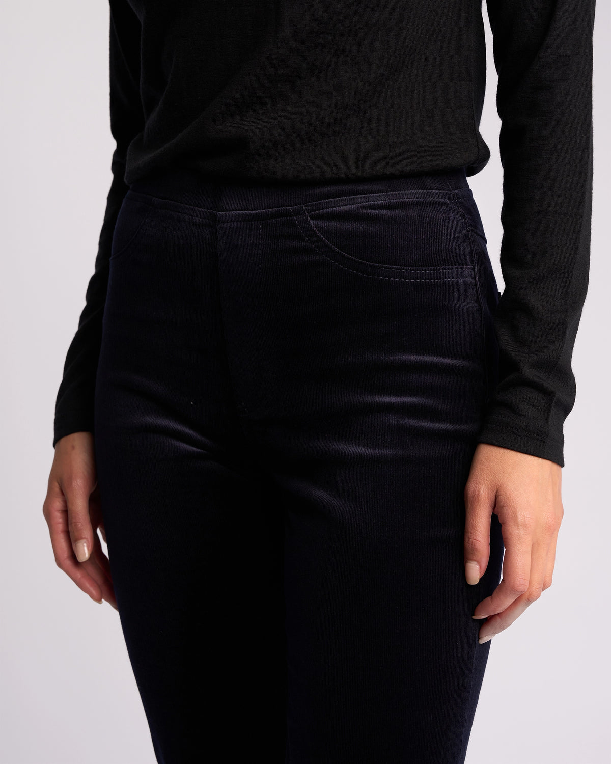 Wearing the Vassalli Bay Cord Pull On - Midnight, a person stands with arms relaxed at their sides against a plain light background.