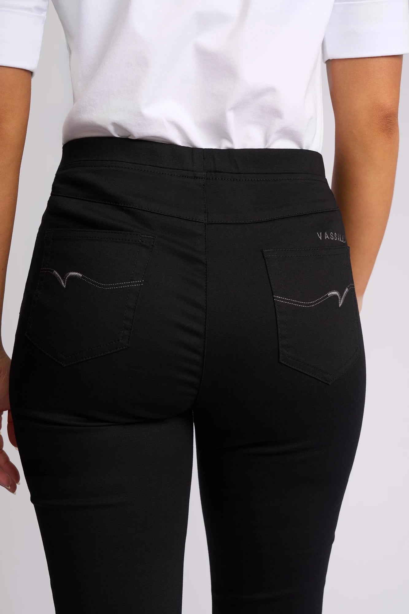 A person is shown from the back wearing a white top and the Vassalli Harbour 7/8 Pant in Black, highlighting the pocket stitching and the fit of these skinny-leg pull-on pants made from comfortable stretch fabric.