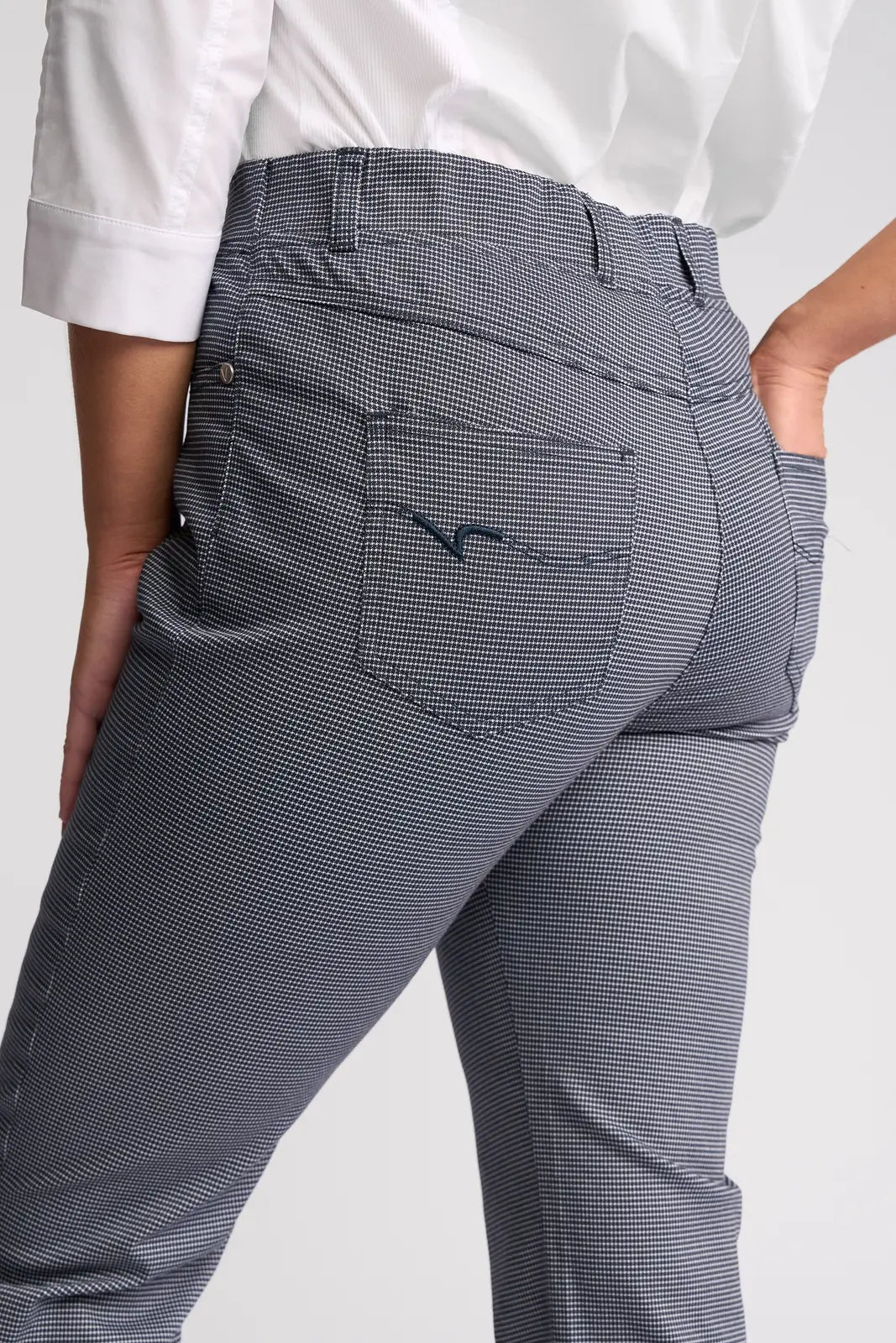 A person wearing Vassalli’s London Pull On - Midnight pants and a white shirt, with one hand in their pocket, shown from the back and slightly to the side—a classic look.