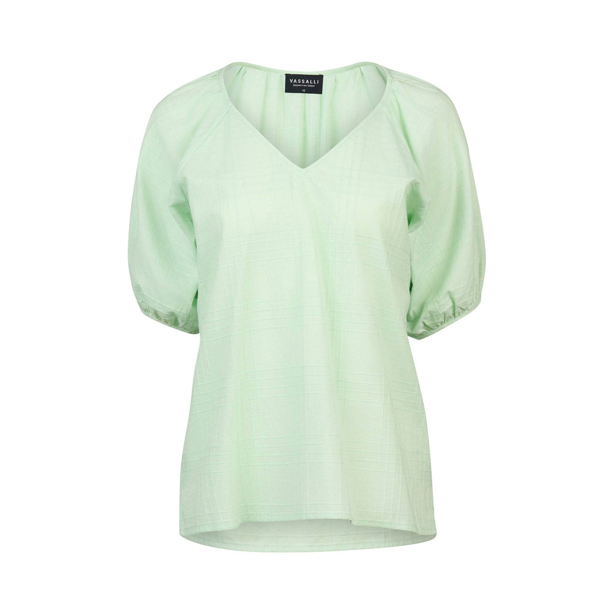 The Pitch Top - Mint by Vassalli is a light green V-neck with short puff sleeves, gathered cuffs, and a subtle textured pattern. Made from soft cotton, it offers a loose, comfortable fit and charming style.