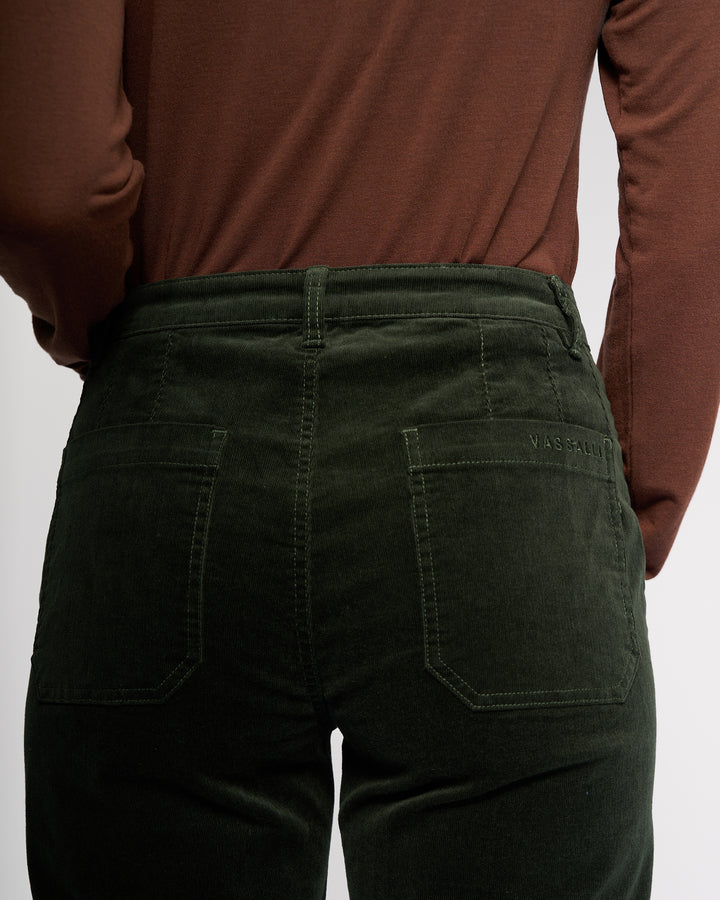 A person is shown from the back wearing a brown long-sleeve shirt and Vassalli’s Market Cord Pant in Forest, highlighting the waist and hips with visible back pockets.