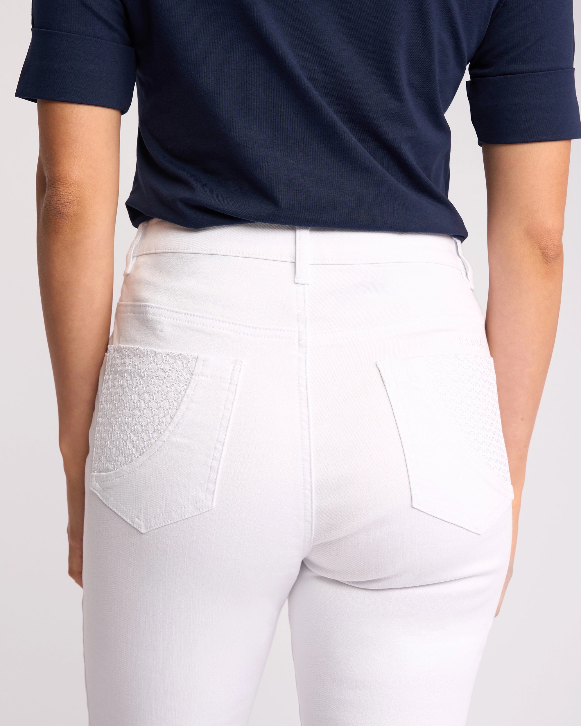 A woman, seen from the back in a navy short-sleeve top and Vassalli’s Reign Jean - White Denim, highlights the textured back pockets that make these women’s NZ denim favorites.