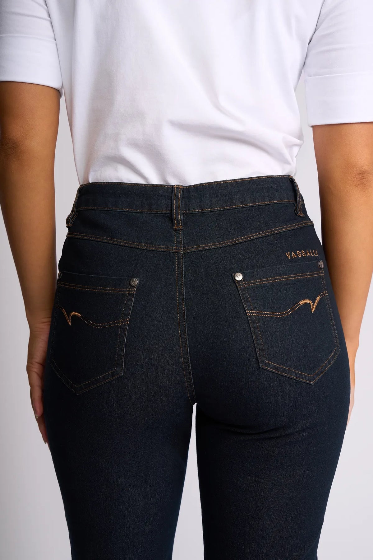 A person wearing a white shirt and dark blue Vassalli Alfa Short - Indigo Denim (Contrast Stitch) is shown from the back, highlighting the fit and design of the shorts’ back pockets.