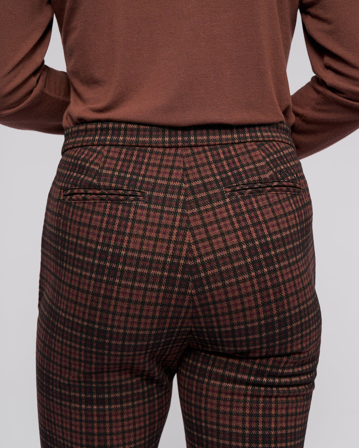 A person is seen from behind wearing Vassalli’s Style Pant - Cherry, featuring a cherry check print, skinny-leg fit, two back pockets, and crafted from stretch knit fabric.