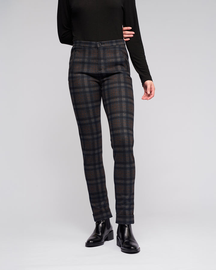 A person models Vassalli's Style Pant - Nomad with a long-sleeve black top and black ankle boots against a plain light gray background. Their face is not visible.