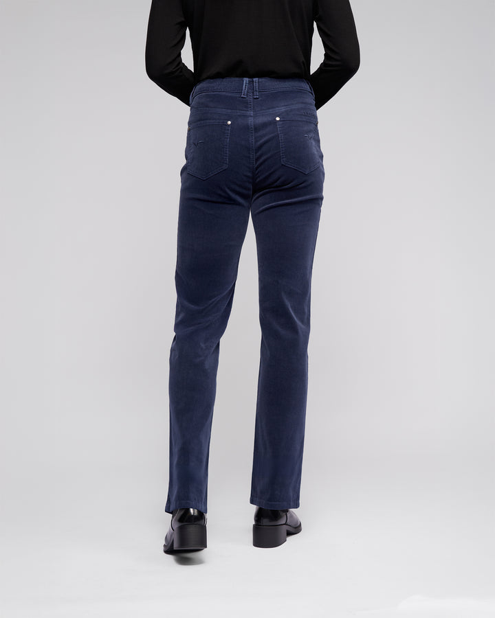 A person is seen from behind against a light gray background, wearing a black long-sleeve top and Vassalli Arch Cord Pant in Slate.