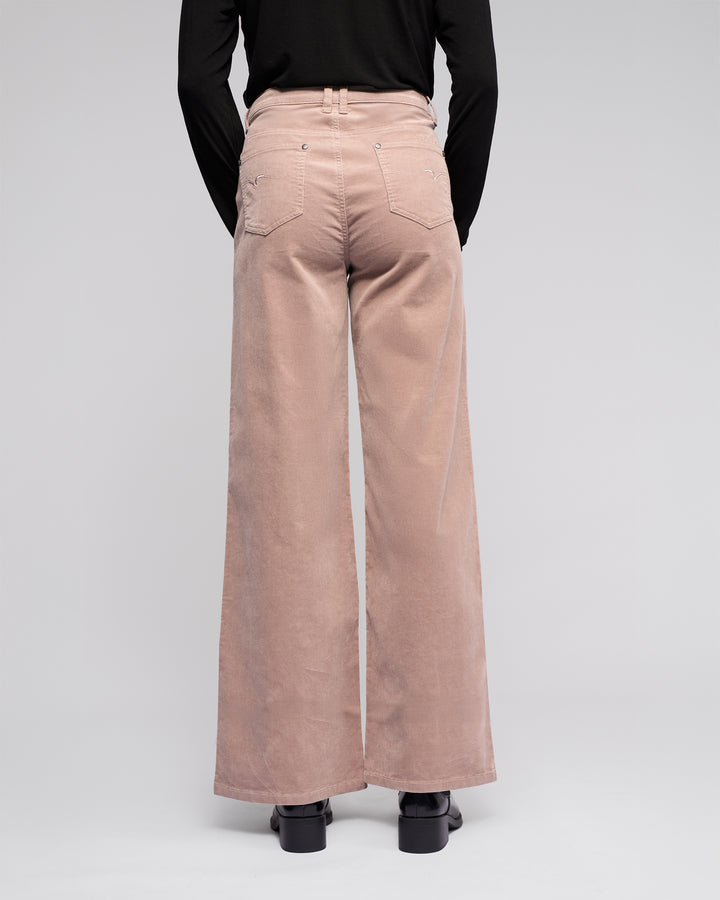 A person models the Vassalli Empire Cord Pant in Twig, a high-waisted, wide-leg corduroy style, paired with a black long-sleeve top and shown from the back against a plain light background.