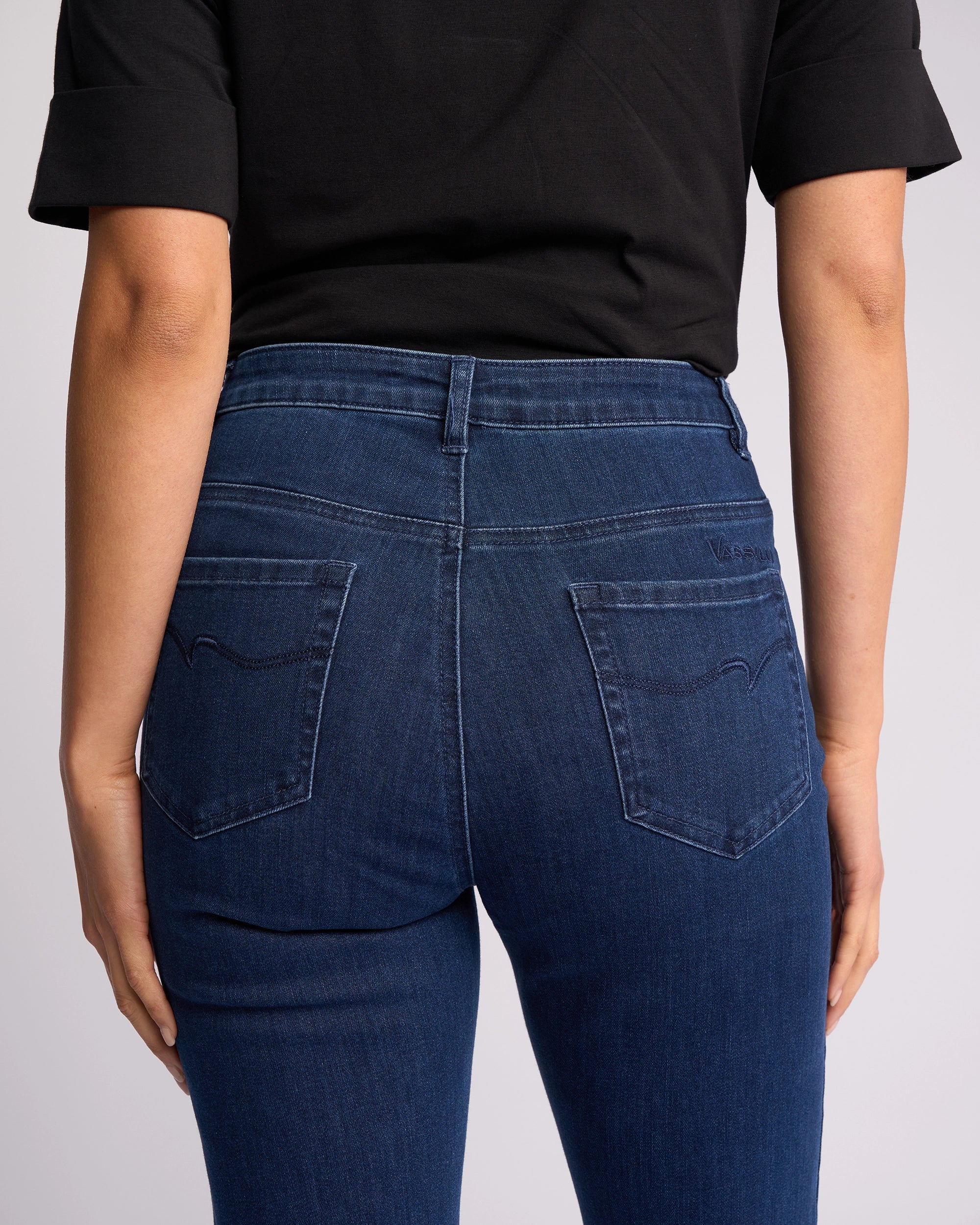A person in a black shirt and Vassalli Theory Jean - Blue Denim (Without Fade) is shown from the back, arms relaxed, highlighting the jeans’ fit and pockets.