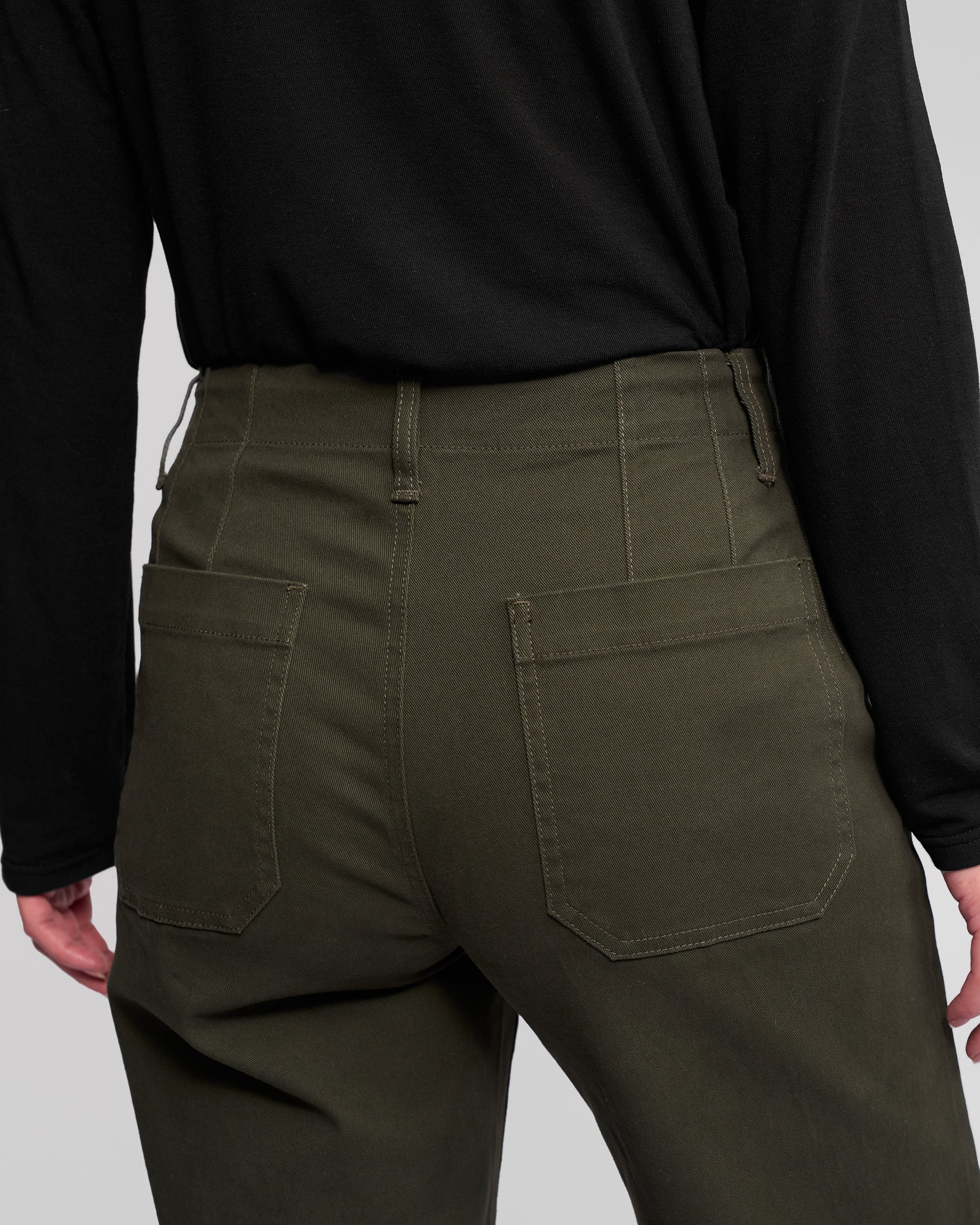 A person wearing a black long-sleeve shirt and Vassalli's Daily Jean - Hunter, shown from the waist down and viewed from behind, with visible back pockets and belt loops on the jeans.
