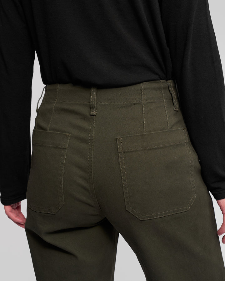 A person wearing a black long-sleeve shirt and Vassalli's Daily Jean - Hunter, shown from the waist down and viewed from behind, with visible back pockets and belt loops on the jeans.