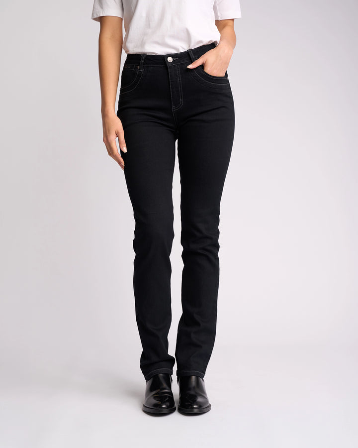 Someone stands against a plain white background wearing a white t-shirt, Vassalli Studio Jean - Black Denim, and black shoes, with one hand in their pocket.