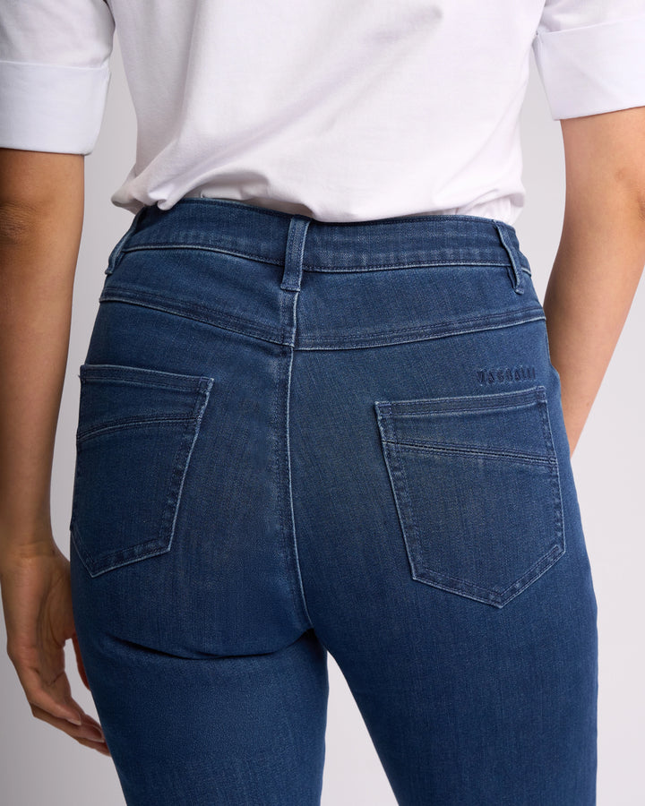 A person is shown from the back wearing Vassalli’s Studio Jean - Blue Denim, featuring two back pockets, belt loops, and a classic denim style with a white short-sleeve shirt. Focus is on the waist and upper legs.
