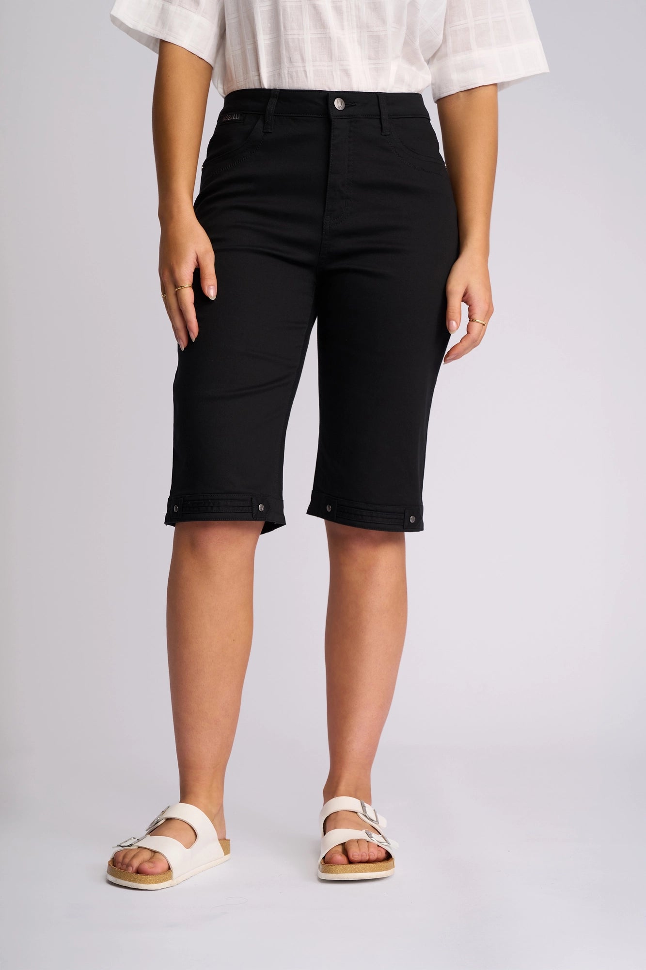 A person stands against a plain light background wearing the Vassalli Custom Lightweight Short in black. Their hands are at their sides, and their face is not visible.