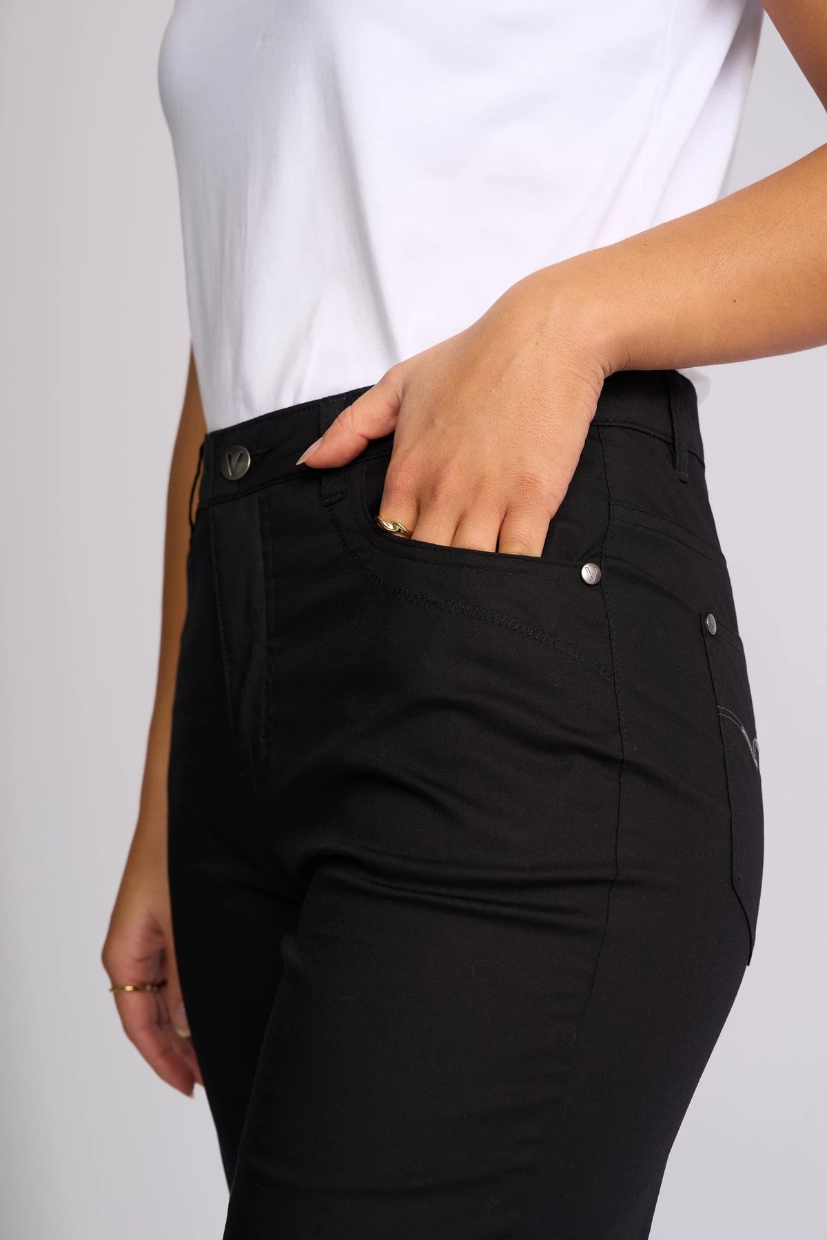 A person wearing Vassalli’s Custom Poplin Short in black with a crisp white poplin short-sleeve shirt, one hand casually resting in their pocket—an effortless summer staple.