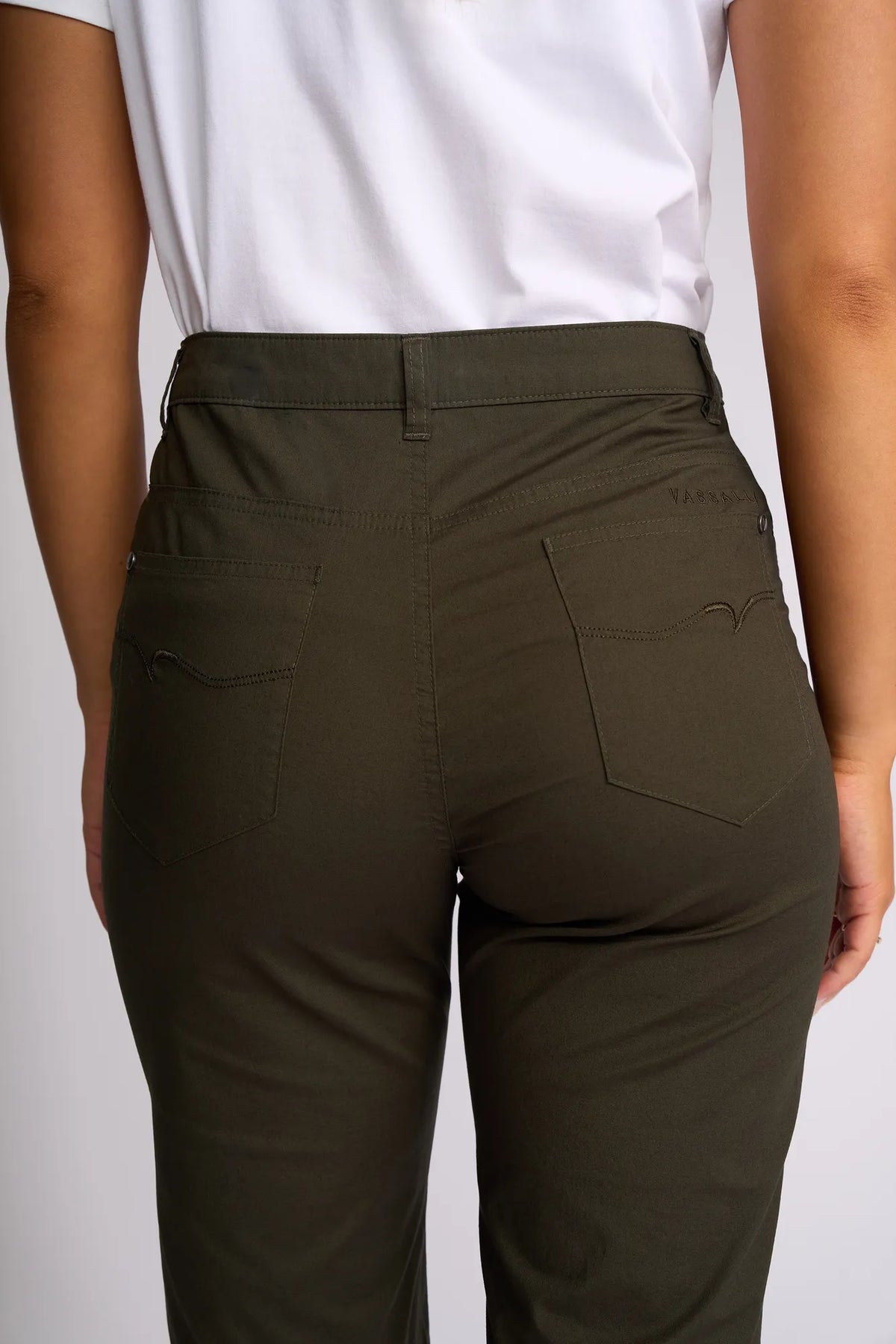 A person is shown from the back wearing a white shirt and Vassalli Custom Poplin Short - Khaki. The straight-leg shorts feature two rear pockets with subtle stitching details, with the image focusing on the waist and upper legs.